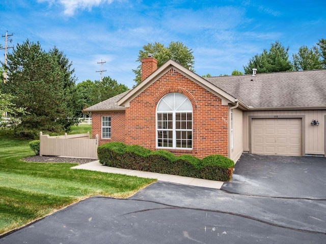 ranch-style house featuring a front yard and a garage