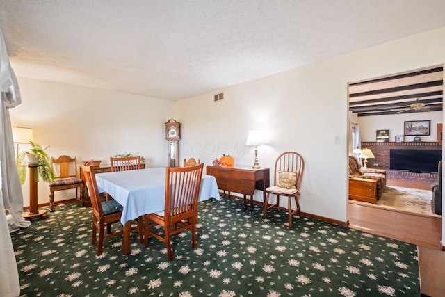 carpeted dining area with a textured ceiling