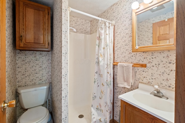 bathroom featuring a textured ceiling, vanity, toilet, and walk in shower