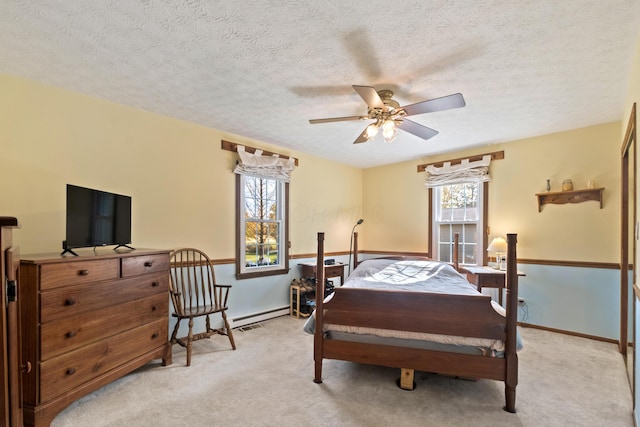 bedroom featuring ceiling fan, light carpet, and a textured ceiling