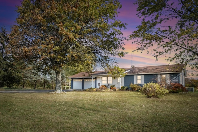 view of front facade featuring a garage and a lawn