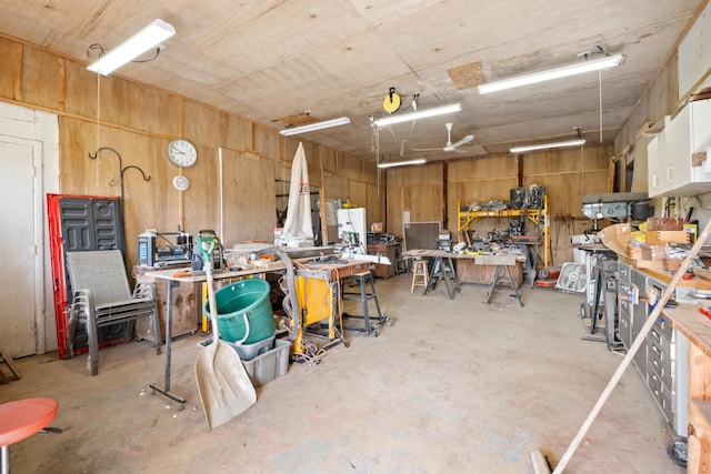 misc room with a workshop area and wooden walls