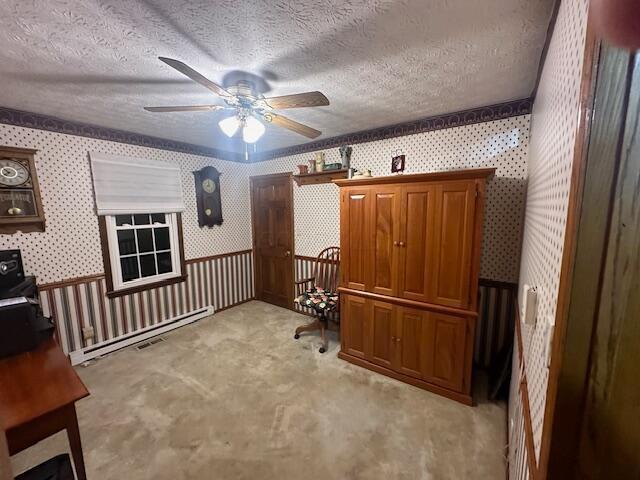 home office with a textured ceiling, light colored carpet, and ceiling fan