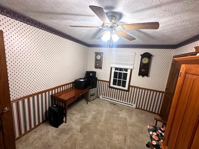 miscellaneous room featuring a textured ceiling, light colored carpet, a baseboard radiator, and ceiling fan