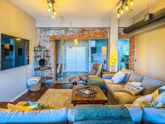 living room with dark wood-type flooring and brick wall