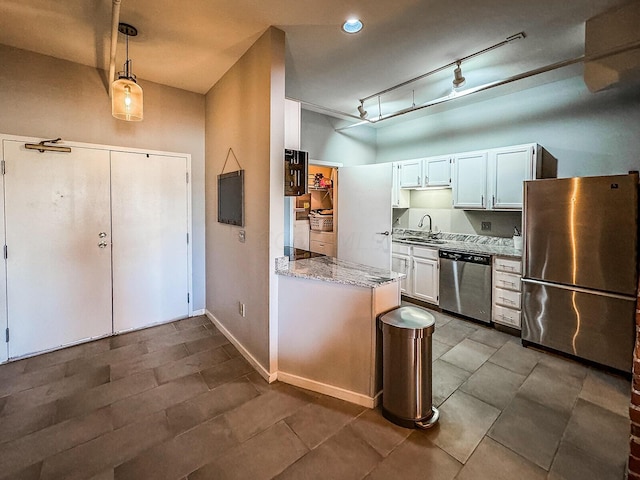 kitchen with light stone countertops, stainless steel appliances, sink, decorative light fixtures, and white cabinetry