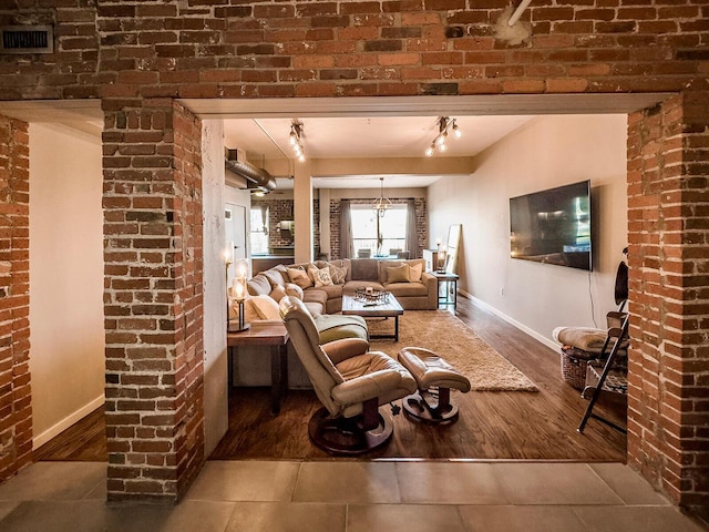 living room featuring hardwood / wood-style floors, track lighting, and an inviting chandelier