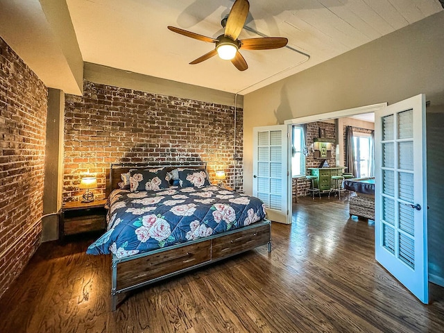 bedroom with ceiling fan, dark hardwood / wood-style floors, and brick wall