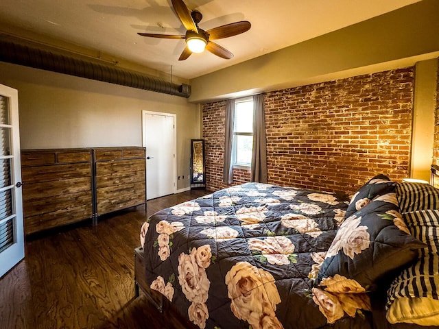 bedroom featuring ceiling fan, dark wood-type flooring, and brick wall