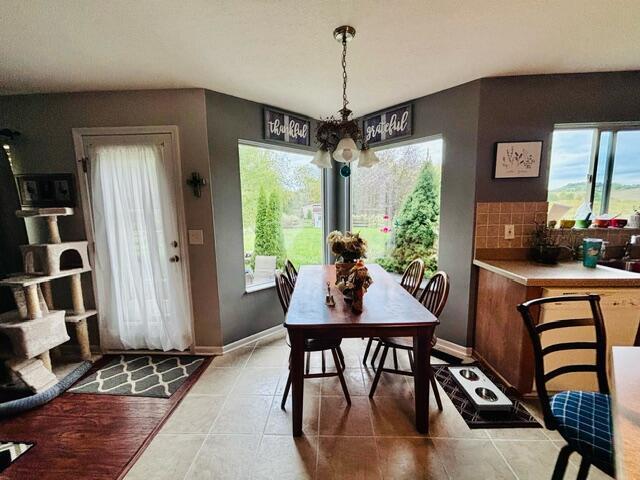 dining room with light tile patterned flooring and a notable chandelier