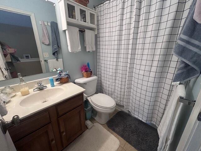 bathroom with tile patterned flooring, vanity, and toilet