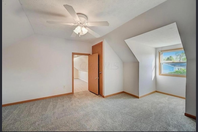 bonus room featuring a textured ceiling, ceiling fan, light carpet, and vaulted ceiling