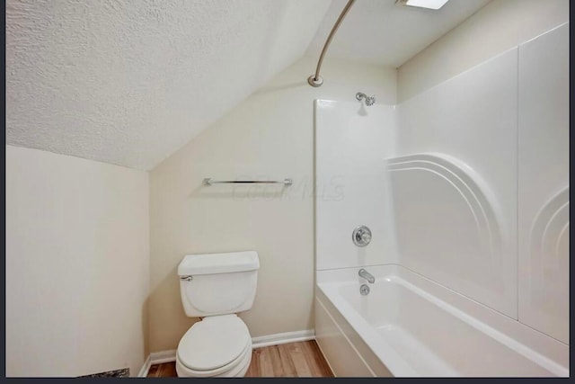 bathroom with shower / bath combination, a textured ceiling, hardwood / wood-style floors, toilet, and lofted ceiling