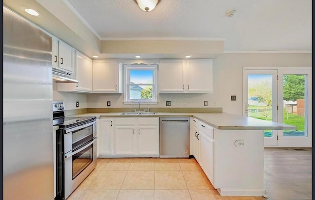 kitchen featuring kitchen peninsula, appliances with stainless steel finishes, ornamental molding, sink, and white cabinets