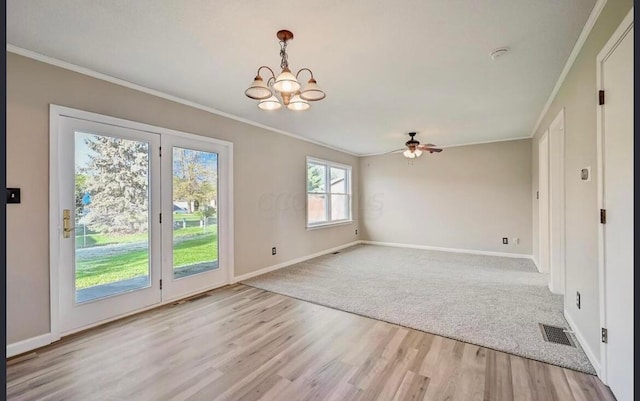 interior space featuring ceiling fan with notable chandelier, light hardwood / wood-style floors, and crown molding