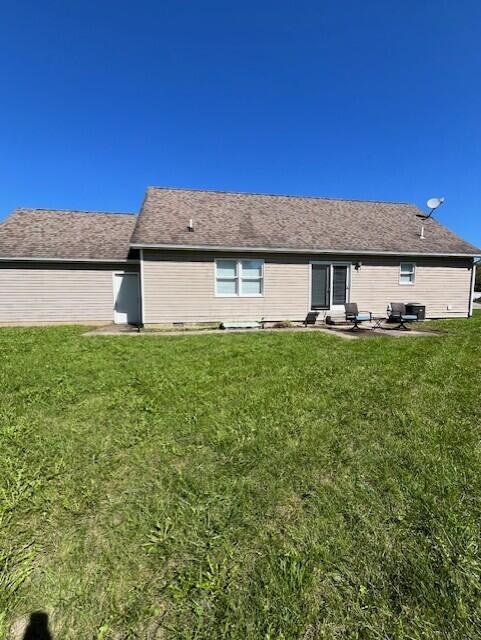 back of house featuring a lawn and a patio