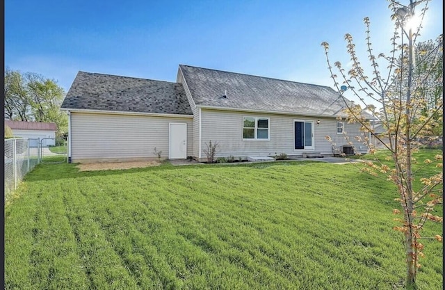 rear view of house with a yard and cooling unit