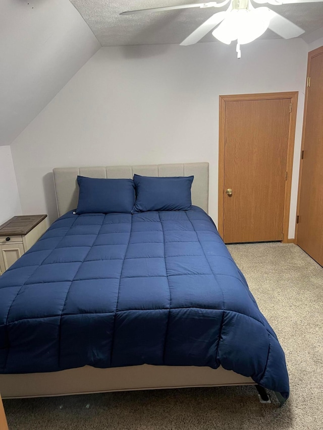 bedroom with ceiling fan, carpet flooring, and lofted ceiling