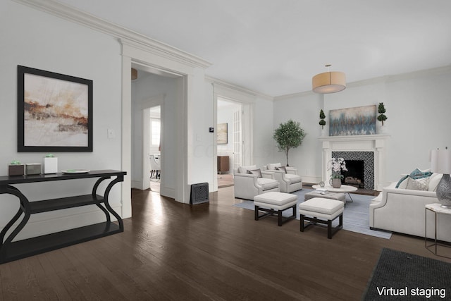 living room featuring crown molding, dark hardwood / wood-style flooring, and a fireplace