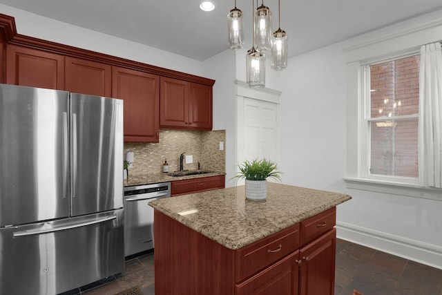 kitchen featuring backsplash, stainless steel appliances, sink, decorative light fixtures, and a kitchen island