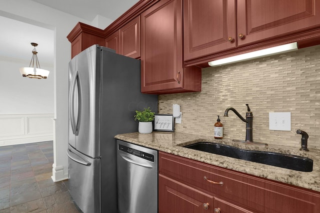 kitchen featuring backsplash, light stone counters, sink, and stainless steel appliances