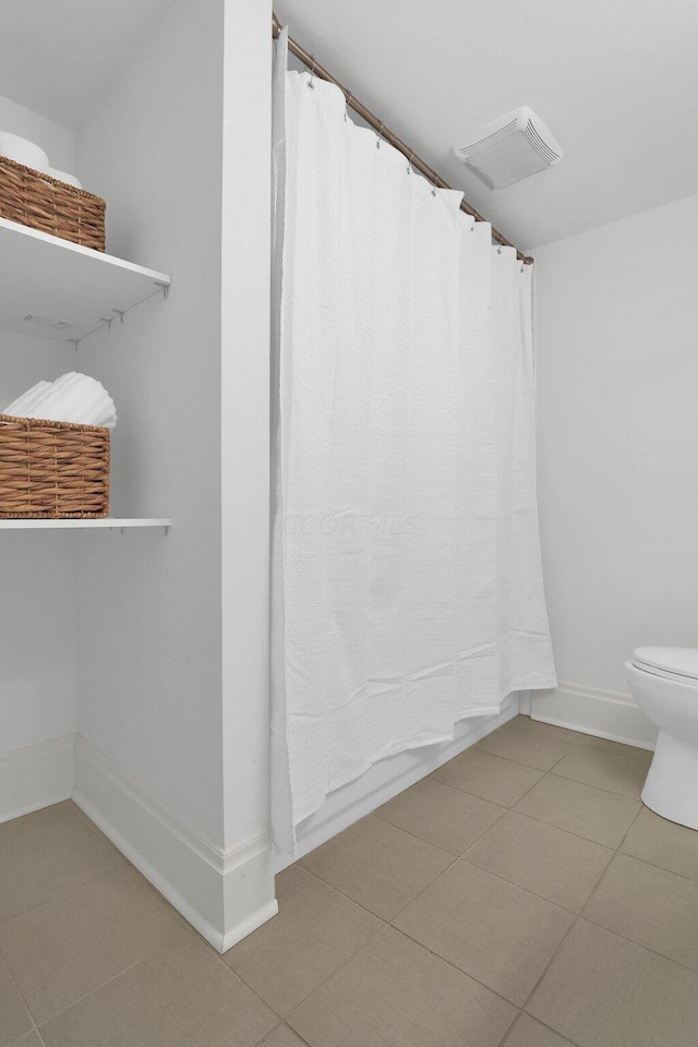 bathroom featuring tile patterned flooring and toilet