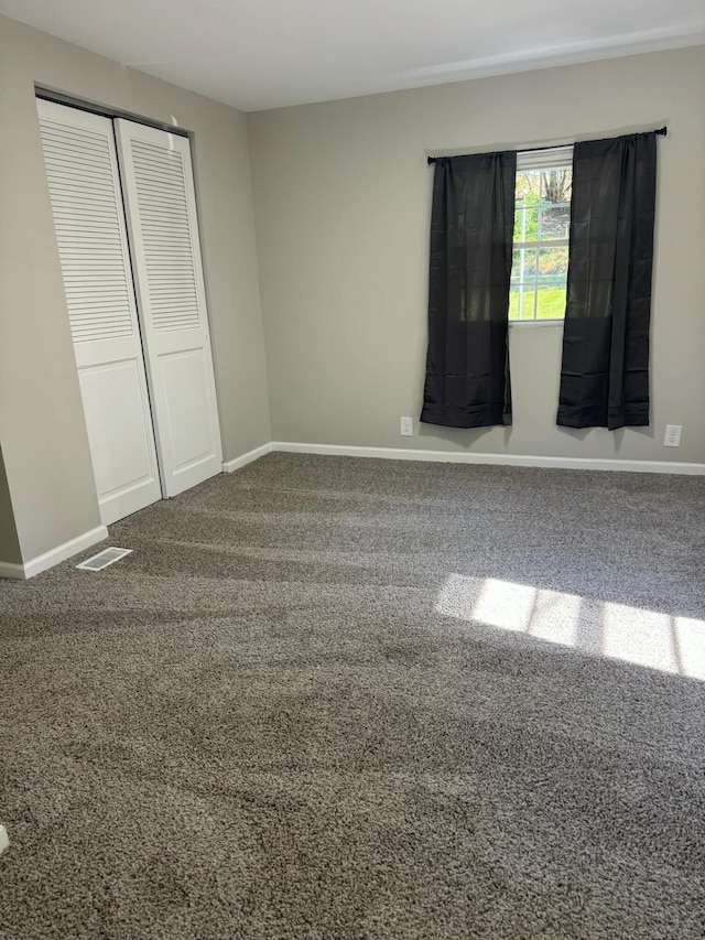 unfurnished bedroom featuring carpet flooring and a closet