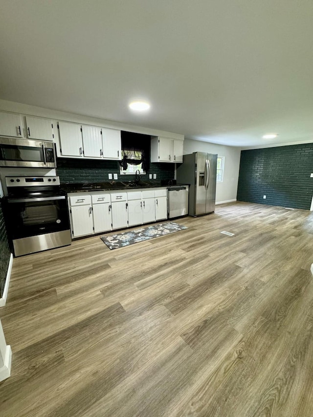 kitchen featuring white cabinets, sink, appliances with stainless steel finishes, tasteful backsplash, and light hardwood / wood-style floors