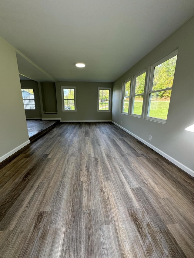 unfurnished living room with dark wood-type flooring