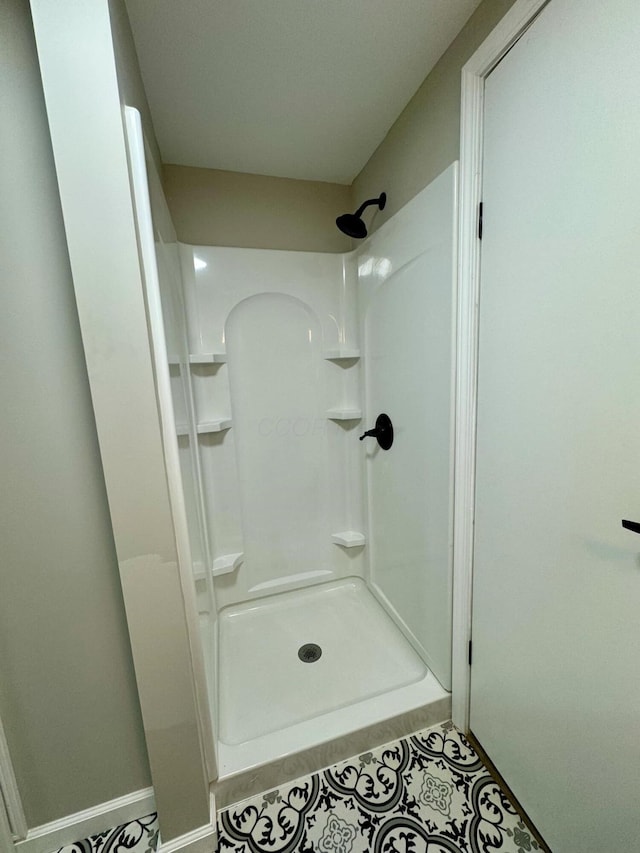 bathroom with a shower and tile patterned flooring