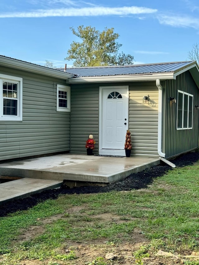 doorway to property with a lawn