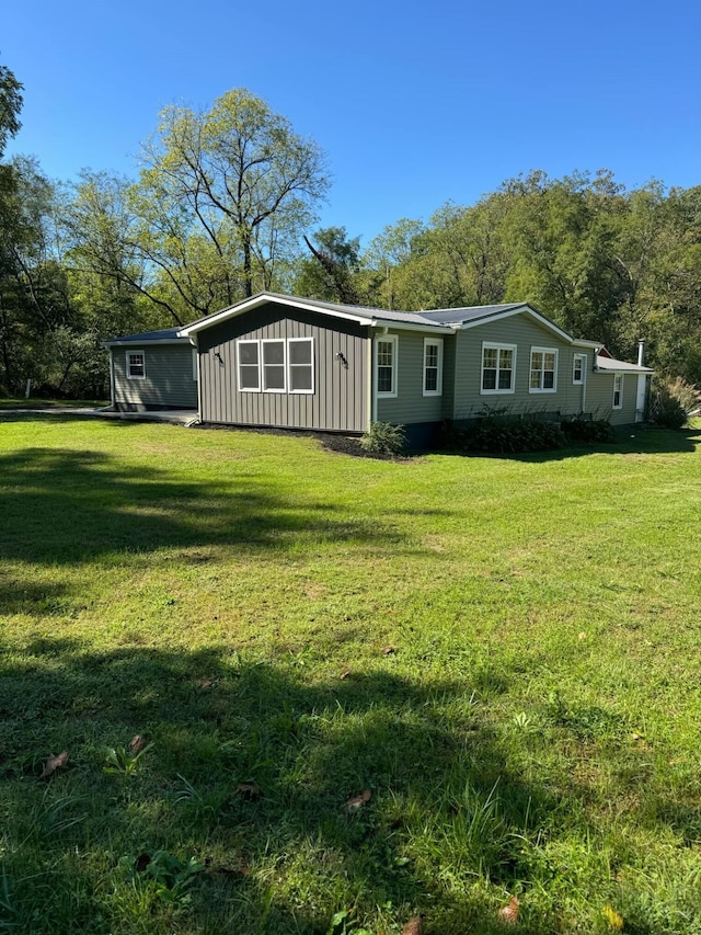 rear view of property featuring a lawn