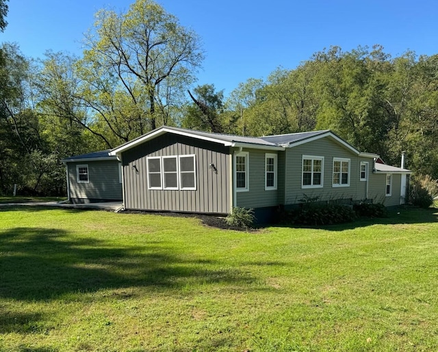 rear view of property with a yard