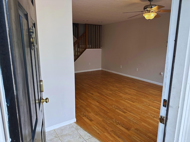 entryway with ceiling fan, a textured ceiling, and light hardwood / wood-style flooring