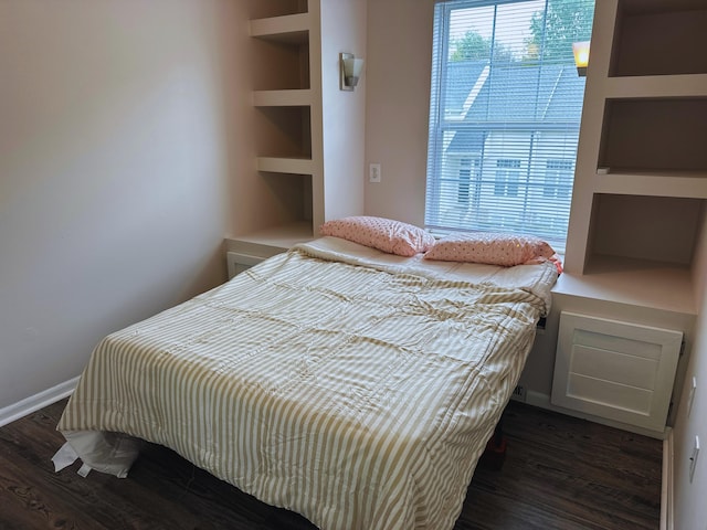 bedroom with dark hardwood / wood-style floors