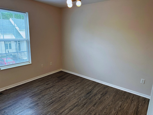 unfurnished room featuring dark hardwood / wood-style floors and a notable chandelier