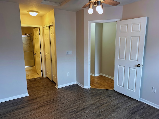 unfurnished bedroom with ceiling fan, a closet, and dark hardwood / wood-style floors