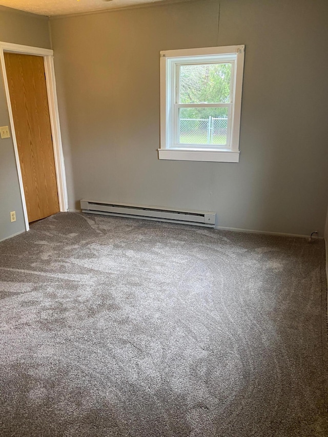 carpeted spare room featuring a baseboard radiator