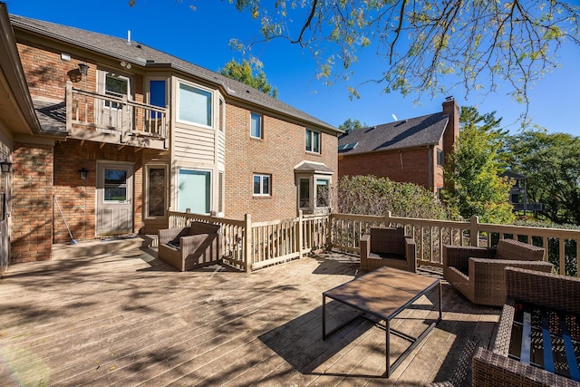 wooden terrace with an outdoor living space