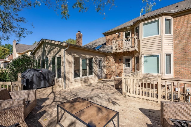 rear view of house featuring a balcony and a deck