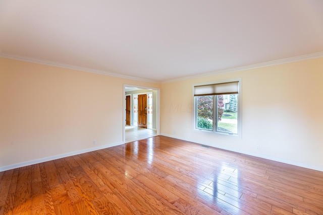 unfurnished room featuring french doors, ornamental molding, and light wood-type flooring