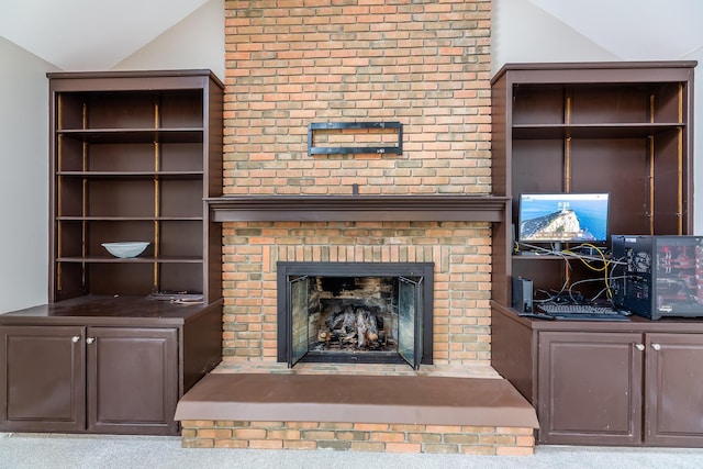 carpeted living room featuring a fireplace and vaulted ceiling