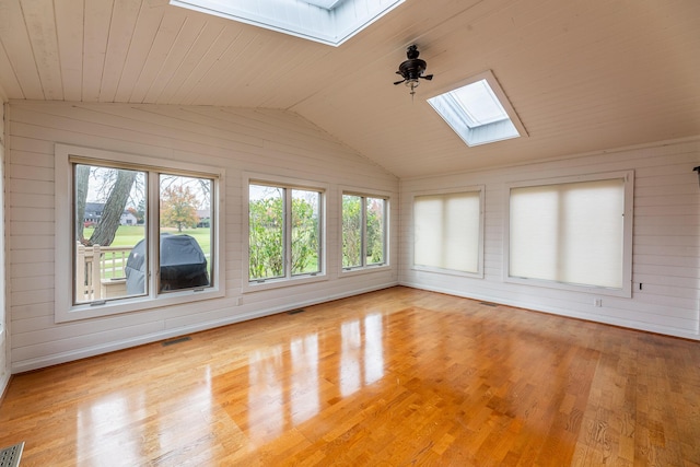 unfurnished sunroom featuring a healthy amount of sunlight, lofted ceiling with skylight, and wooden ceiling