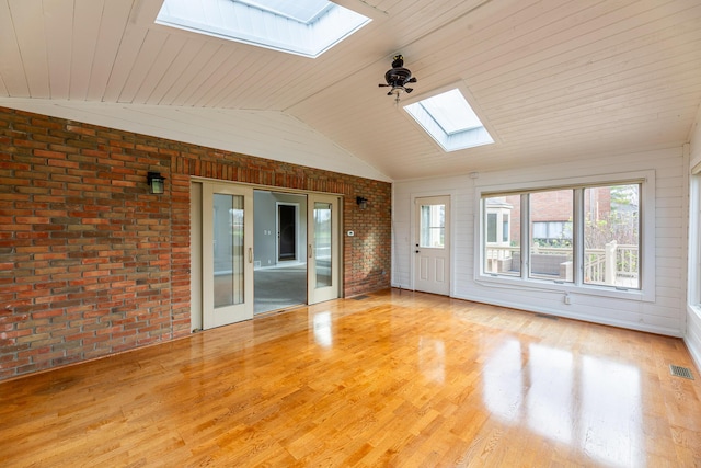 interior space featuring french doors, light hardwood / wood-style flooring, brick wall, lofted ceiling with skylight, and wood ceiling