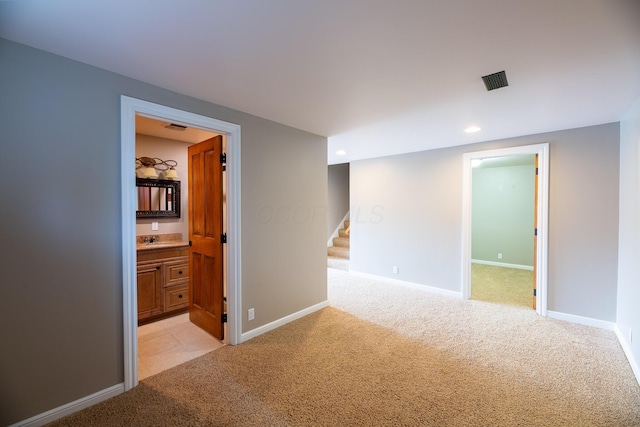 spare room with sink and light colored carpet