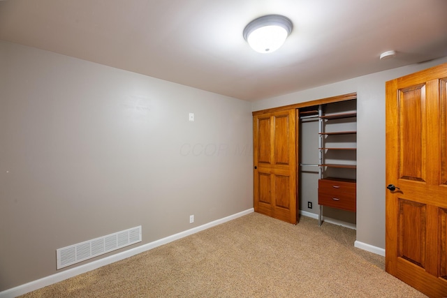 unfurnished bedroom with light carpet and a closet