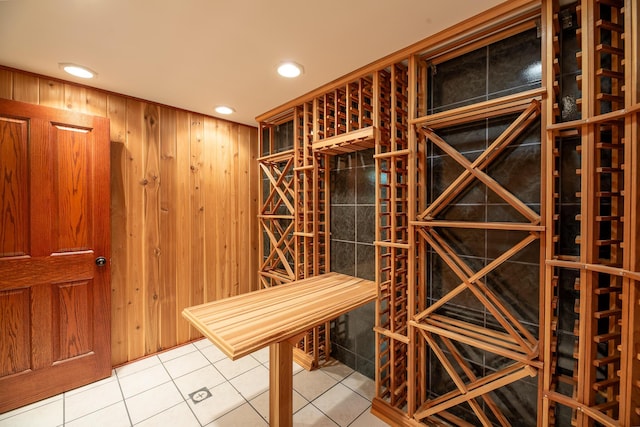 wine cellar with tile patterned floors and wood walls