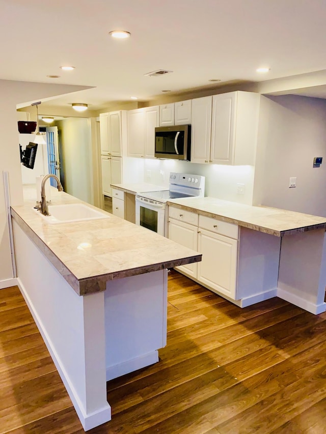 kitchen featuring sink, white electric stove, kitchen peninsula, and white cabinets