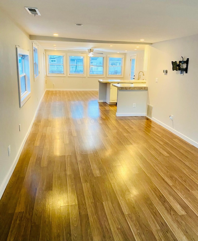 unfurnished living room featuring light hardwood / wood-style flooring and ceiling fan