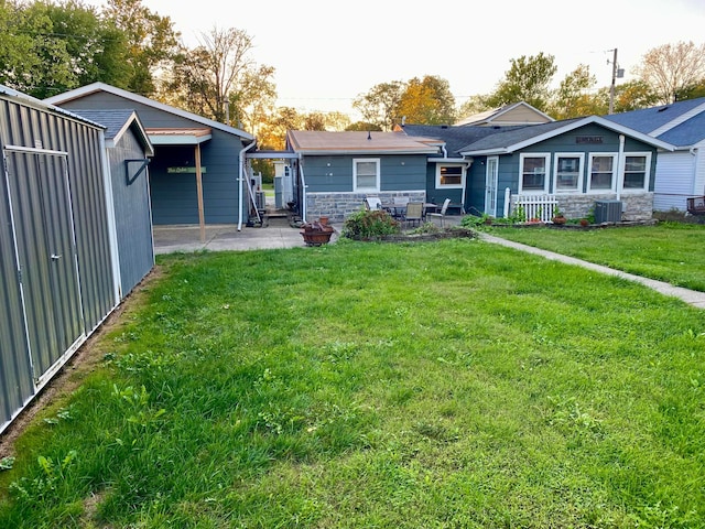 back of house with a patio area, central air condition unit, and a lawn